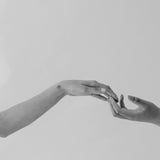 zwei Frauenhände berühren sich an den Fingerspitzen
